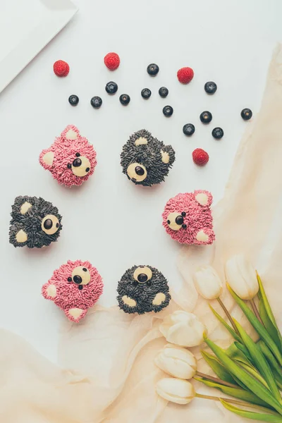 Vista dall'alto di deliziosi muffin fruttati a forma di orsi e bellissimi tulipani — Foto stock