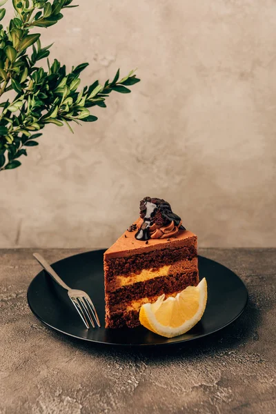 Stück leckerer Kuchen mit Schokolade und Zitrone auf Teller — Stockfoto