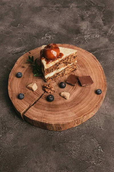 Piece of gourmet cake with chocolate and blueberries on wooden board — Stock Photo