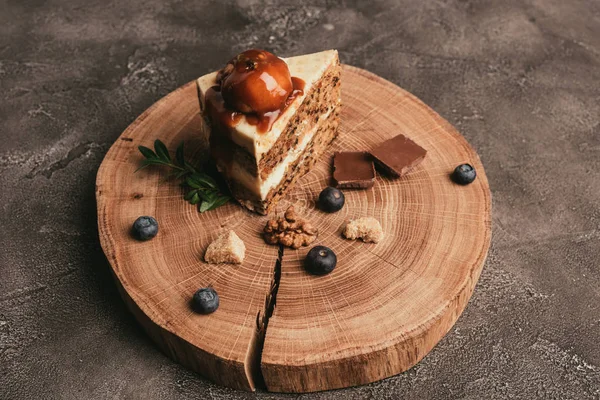 Delizioso pezzo di torta con cioccolato e mirtilli su tavola di legno — Foto stock