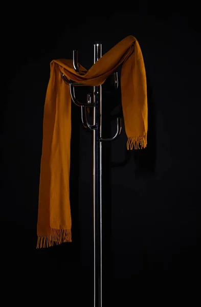 Жовтий шарф, що висить на стелажі пальто ізольований на чорному — стокове фото