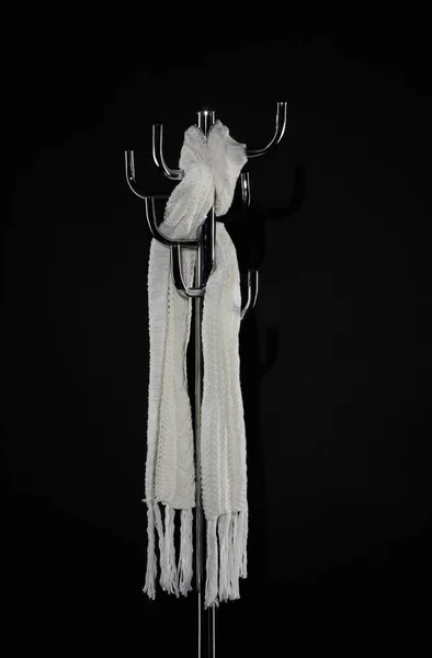 Белый шарф висит на вешалке, изолированный на черном — стоковое фото