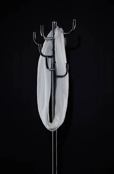 Білий шарф, що звисає на стелажі для пальто ізольований на чорному — стокове фото