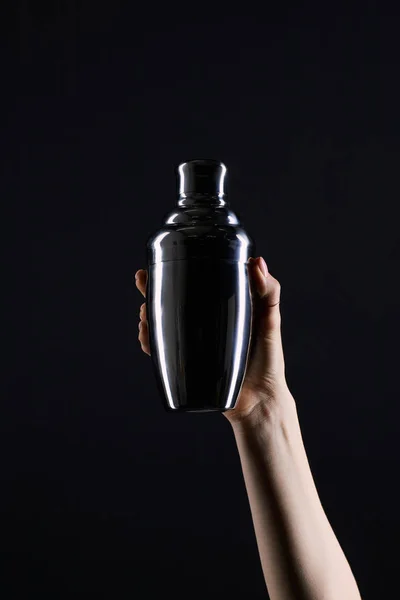 Tiro recortado de mujer sosteniendo coctelera aislado en negro - foto de stock