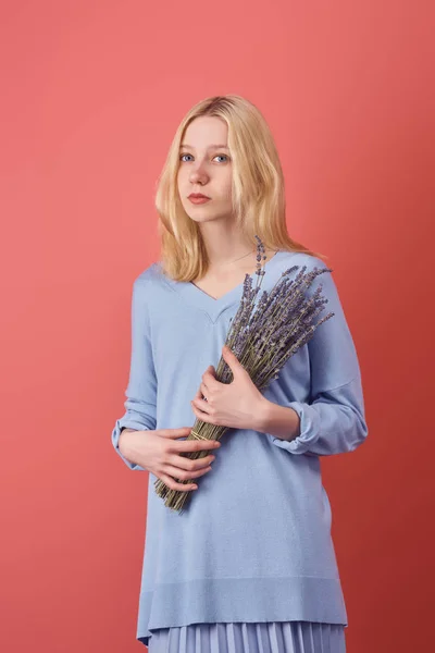 Sensual mujer joven con ramo de flores de lavanda aislado en rojo - foto de stock