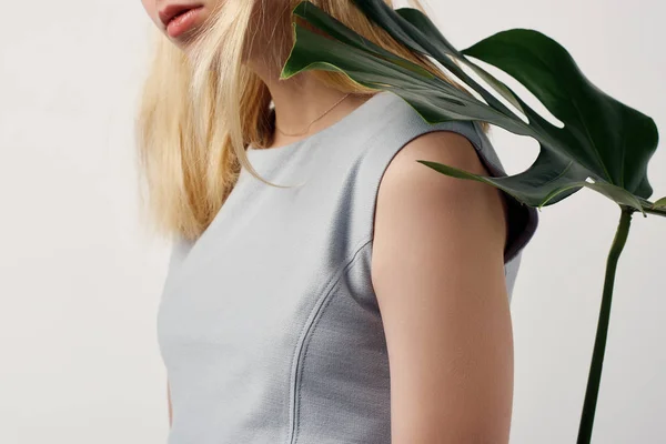 Tiro cortado de mulher jovem atraente com folha monstera no ombro isolado no branco — Fotografia de Stock
