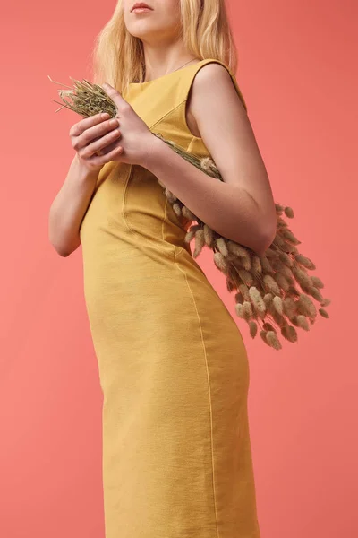 Cropped shot of young woman with bouquet of Lagurus isolated on red — Stock Photo