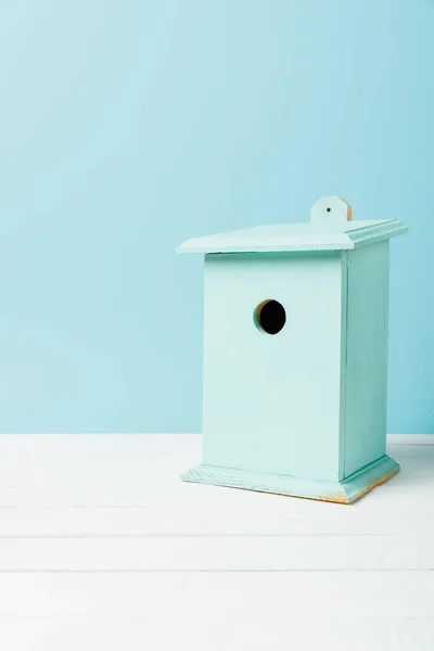 Nahaufnahme von blauem Vogelhaus auf Holzfläche isoliert auf blauem Grund — Stockfoto