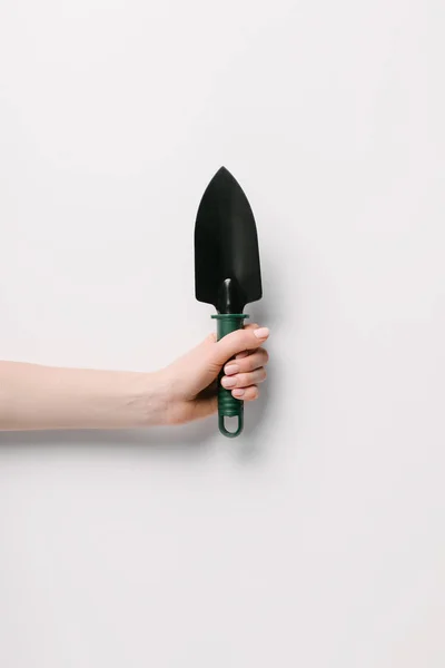 Cropped shot of woman holding gardening shovel in hand isolated on white — Stock Photo