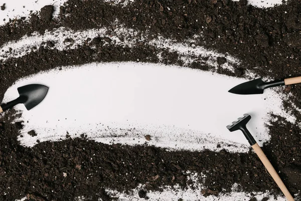 Vue de dessus de l'équipement de jardinage arrangé et le sol isolé sur blanc — Photo de stock