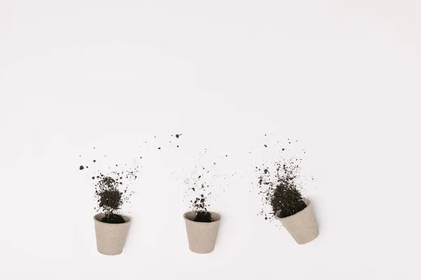 Vue de dessus de trois pots de fleurs avec sol isolé sur blanc — Photo de stock