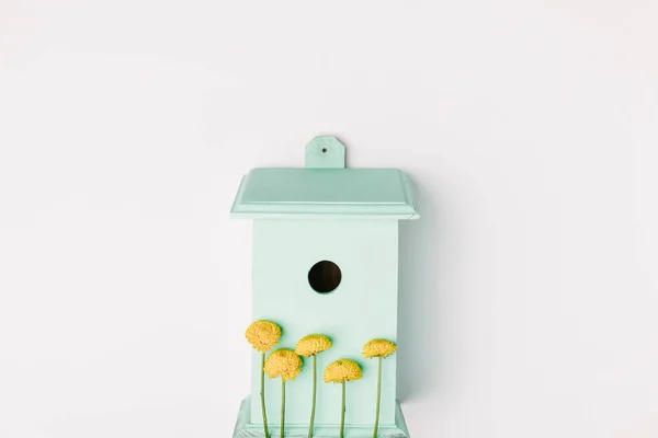 Top view of blue birdhouse with yellow chrysanthemum flowers isolated on white — Stock Photo