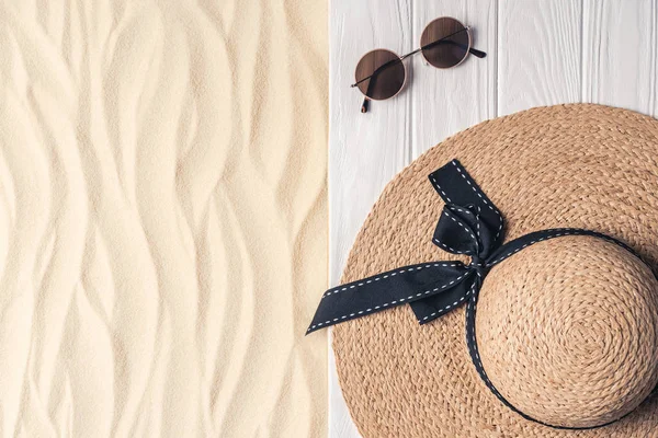 Sombrero de paja y gafas de sol sobre arena clara - foto de stock
