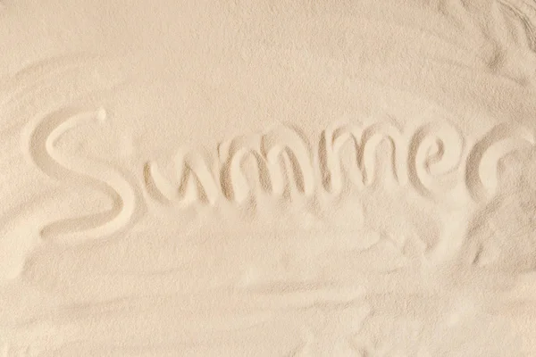 Inscripción de verano en arena de playa clara - foto de stock