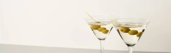 Two glasses of cocktails with olives isolated on white background, panoramic shot — Stock Photo