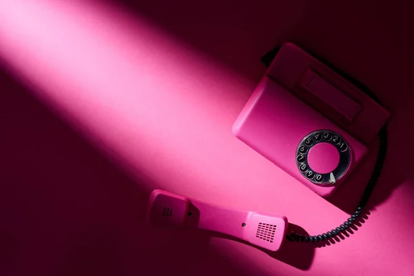 Top view of vintage pink telephone with shadow on bright surface — Stock Photo