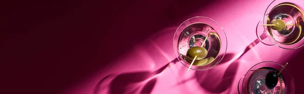 Top view of martini cocktails on bright pink background with shadows, panoramic shot — Stock Photo