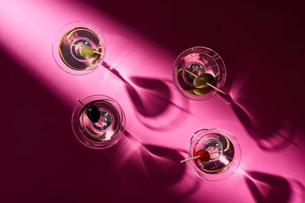 Top view of cocktails with olives on pink background with shadows — Stock Photo