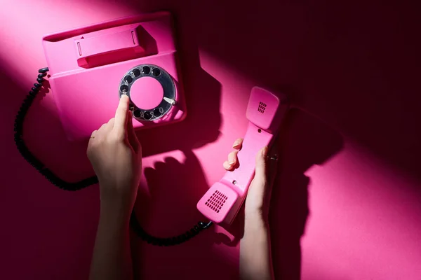 Cropped view of woman using retro telephone on pink background — Stock Photo