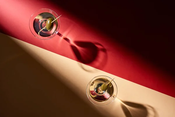 Vista superior de dos cócteles sobre fondo rojo y beige - foto de stock
