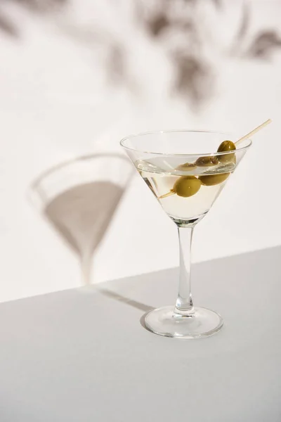 Martini with olives on white background with shadow — Stock Photo