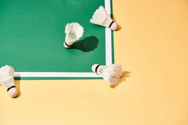 Badminton shuttlecocks on green court and yellow surface — Stock Photo