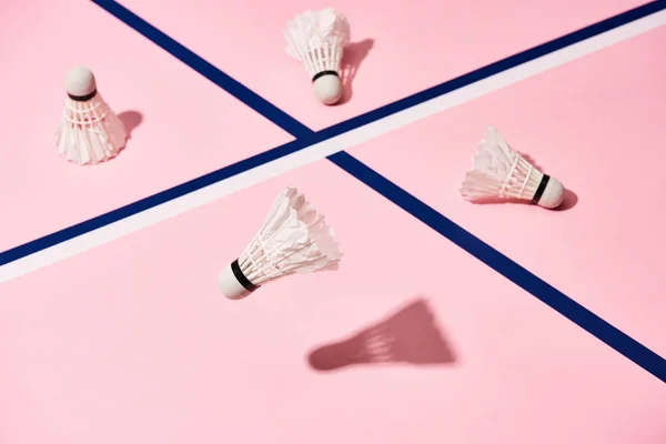 Navettes de badminton avec ombre sur fond rose avec lignes bleues — Photo de stock