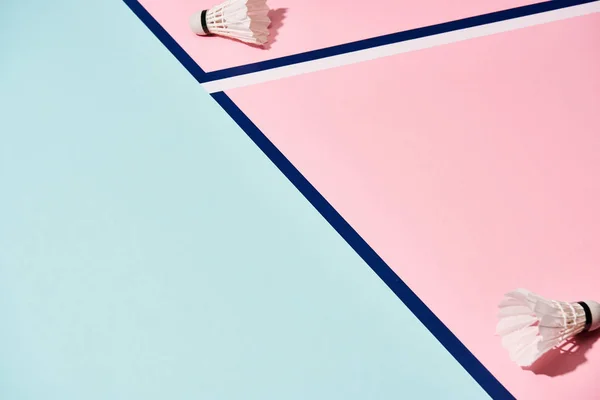 Badminton shuttlecocks em fundo rosa e azul com linhas — Fotografia de Stock