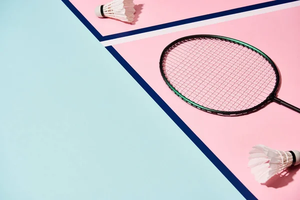 Raqueta de bádminton y lanzaderas en una superficie colorida con líneas azules - foto de stock