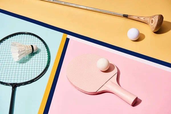Обладнання для бадмінтону, гольфу та настільного тенісу на барвистому фоні з лініями — стокове фото