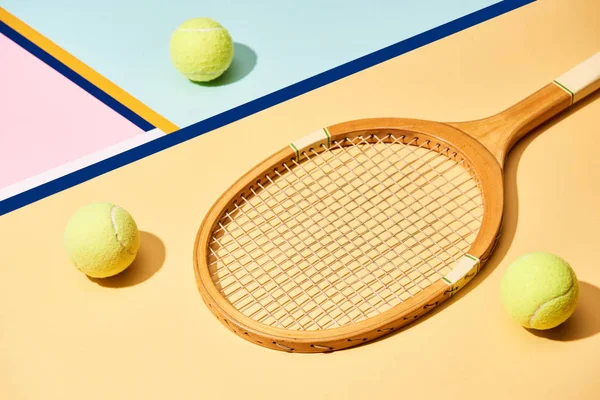 Raqueta de tenis y pelotas sobre fondo colorido con líneas azules - foto de stock