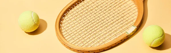 Wooden tennis racket and balls on yellow background, panoramic shot — Stock Photo