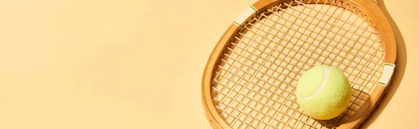 Wooden tennis racket and ball on yellow background, panoramic shot — Stock Photo