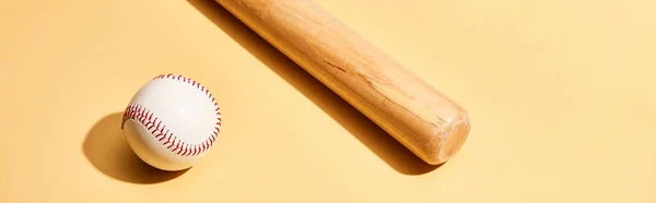 Baseball bat and ball on yellow background, panoramic shot — Stock Photo
