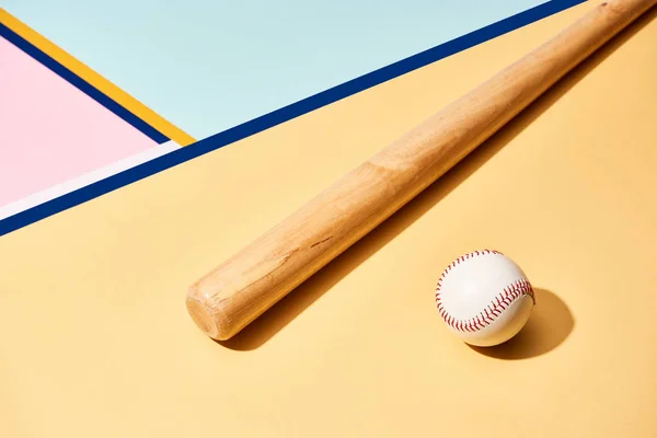 Taco de beisebol de madeira e bola no fundo colorido com linhas — Fotografia de Stock