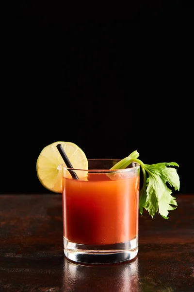 Bloody mary cocktail in glass garnished with lime and celery isolated on black — Stock Photo
