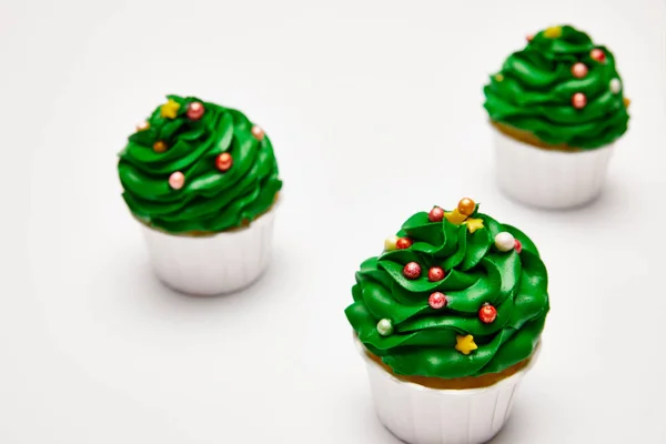 Selective focus of tasty Christmas tree cupcakes on white surface — Stock Photo