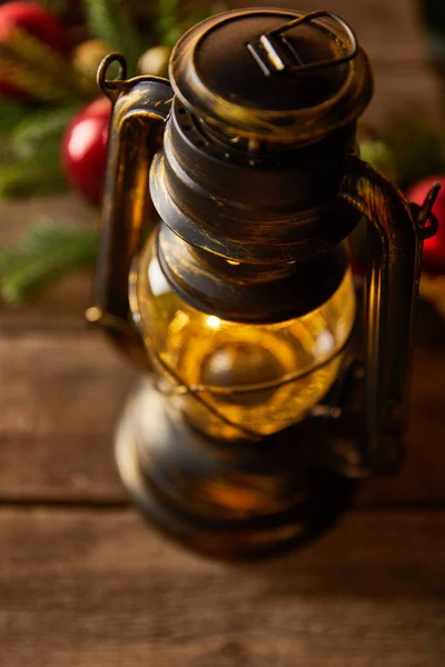 Close up of decorative vintage oil lamp with spruce branches and christmas balls on wooden table — Stock Photo