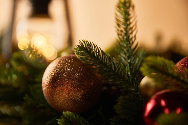 Close up of spruce branches and christmas balls and lights bokeh — Stock Photo