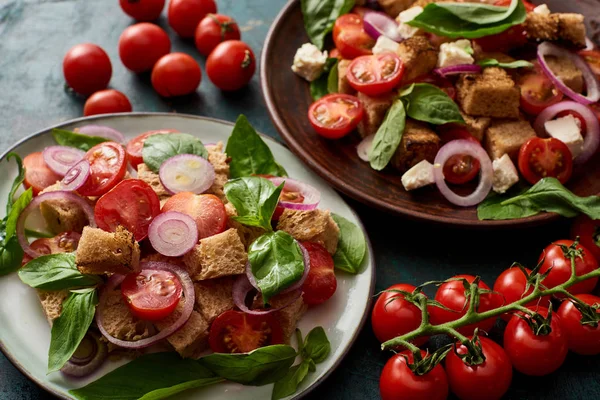 Ensalada de verduras italiana fresca panzanella servido en platos en la mesa con tomates - foto de stock