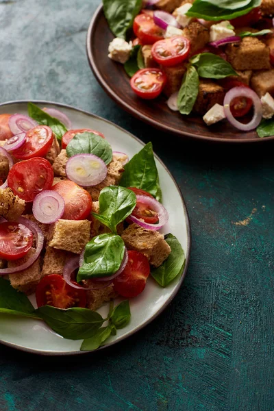 Свежий итальянский овощной салат panzanella подается на тарелках на столе — стоковое фото