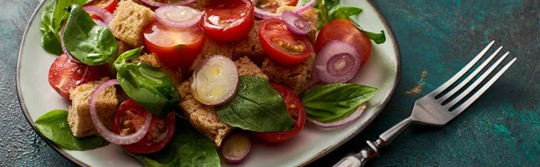 Ensalada de verduras italiana fresca panzanella servida en plato sobre mesa texturizada con tenedor, plano panorámico - foto de stock