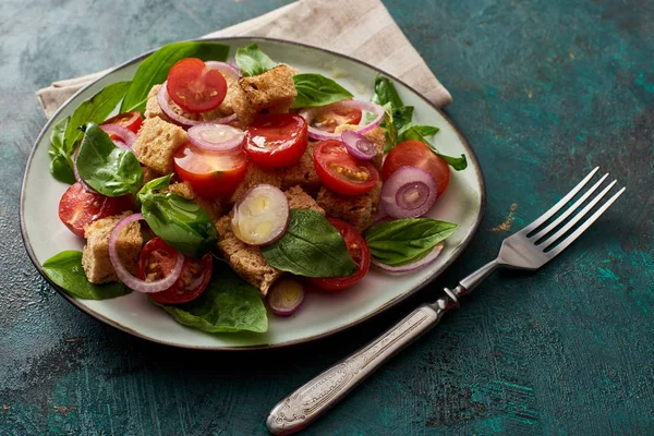 Fresh Italian vegetable salad panzanella served on plate on table with fork and napkin — Stock Photo