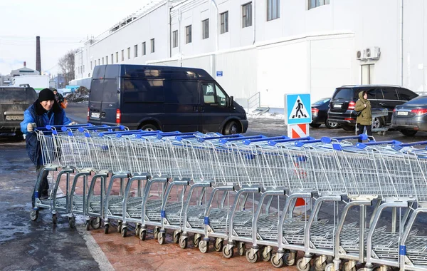 Yükleyici yük arabaları metro hypermarket yakınındaki uzun bir dizi iter. Moskova, Rusya - 02 Mart 2018