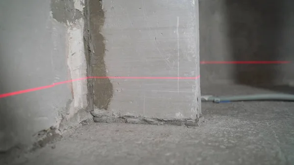 Laser level at work. Laser level and concrete walls and floor. Apartment renovation.