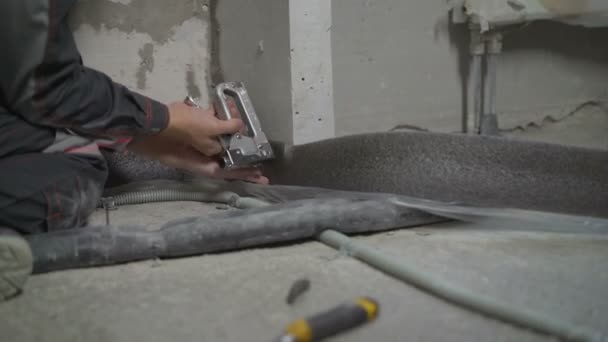 Damper tape for styling. Worker fastens damper tape. The tape is attached to the floor to fill the floor. — Stock Footage Damper tape for styling. Worker fastens damper tape. The tape is attached to the floor to fill the floor. Royalty Free Stock Video