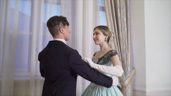 The guy invites the girl to dance. The guy comes to the girl. Costumes of the 19th century. Dance costumes of the 19th century. The gentleman invites the lady to dance. Dance traditions of the 19th ce