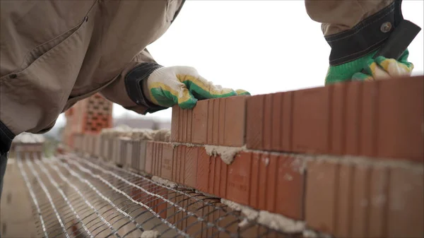 Masonry brick wall with mesh. Work with decorative stone.