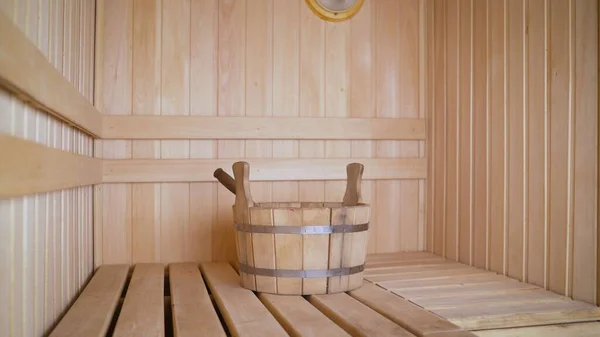 Steam room in a Finnish bath with a wooden basin with water for soaking. Sauna with a wooden basin.