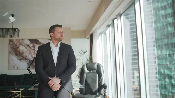 A businessman at the end of the day gets up and goes home. A businessman stands at the table. Single adult business man waiting for meeting to begin in Board room